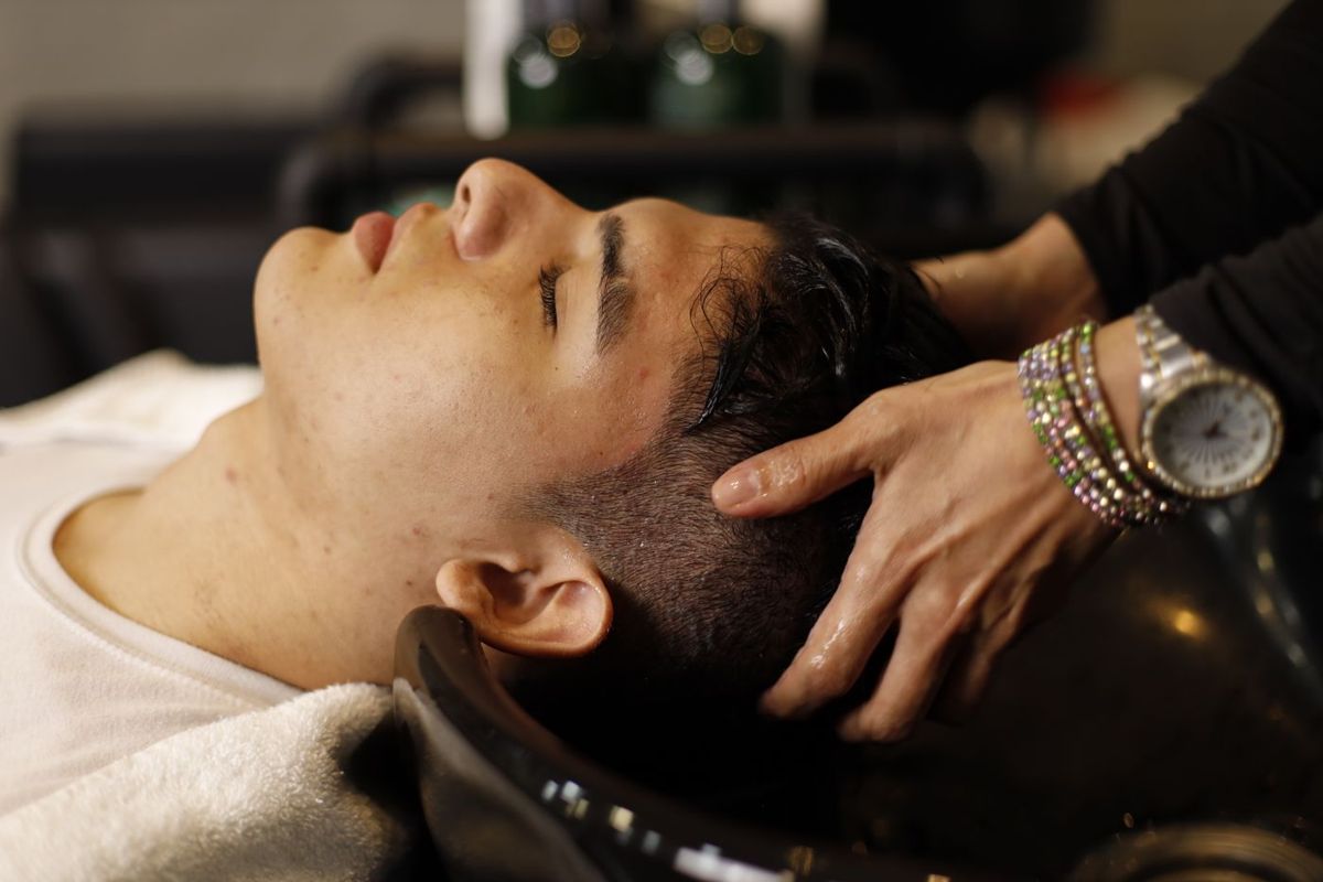 Man with eyes closed during a relaxing scalp massage
